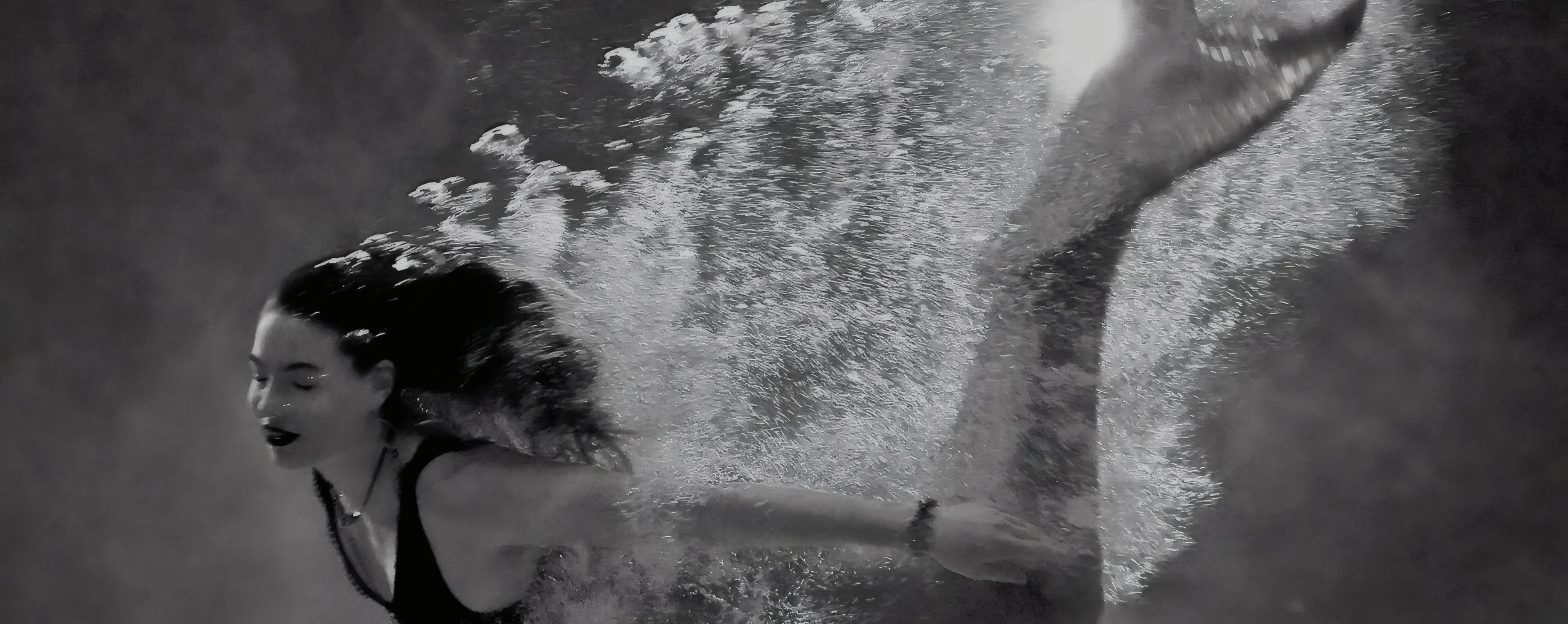 A swimmer under water, in black and white