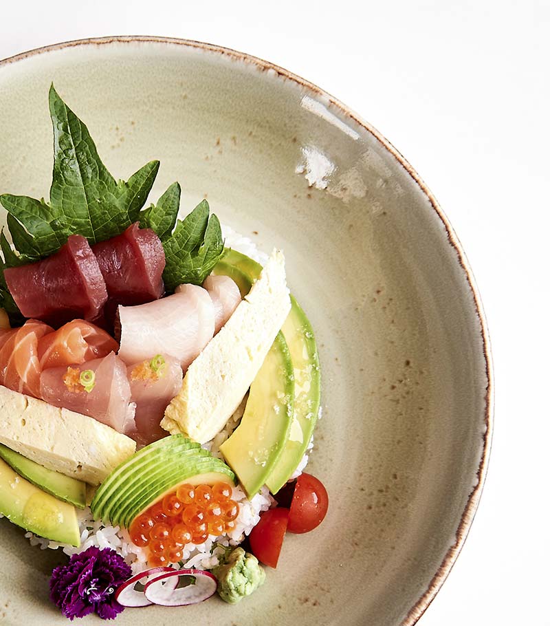 A bowl of tuna and salmon crudo with avocado and rice