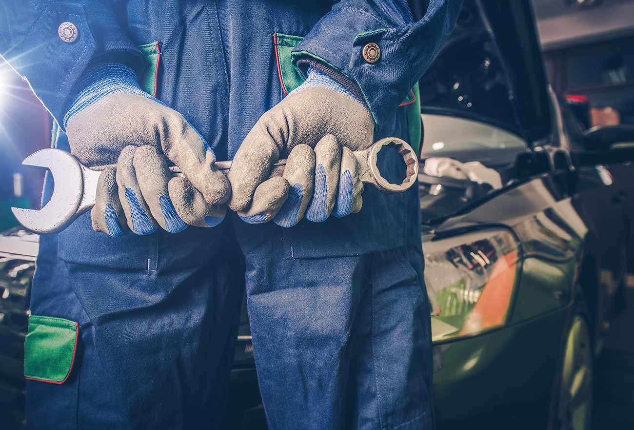 Gloved hands holding spanners