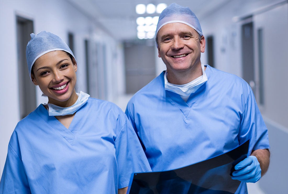 Two Medora surgeons in scrubs, smiling in the corridor