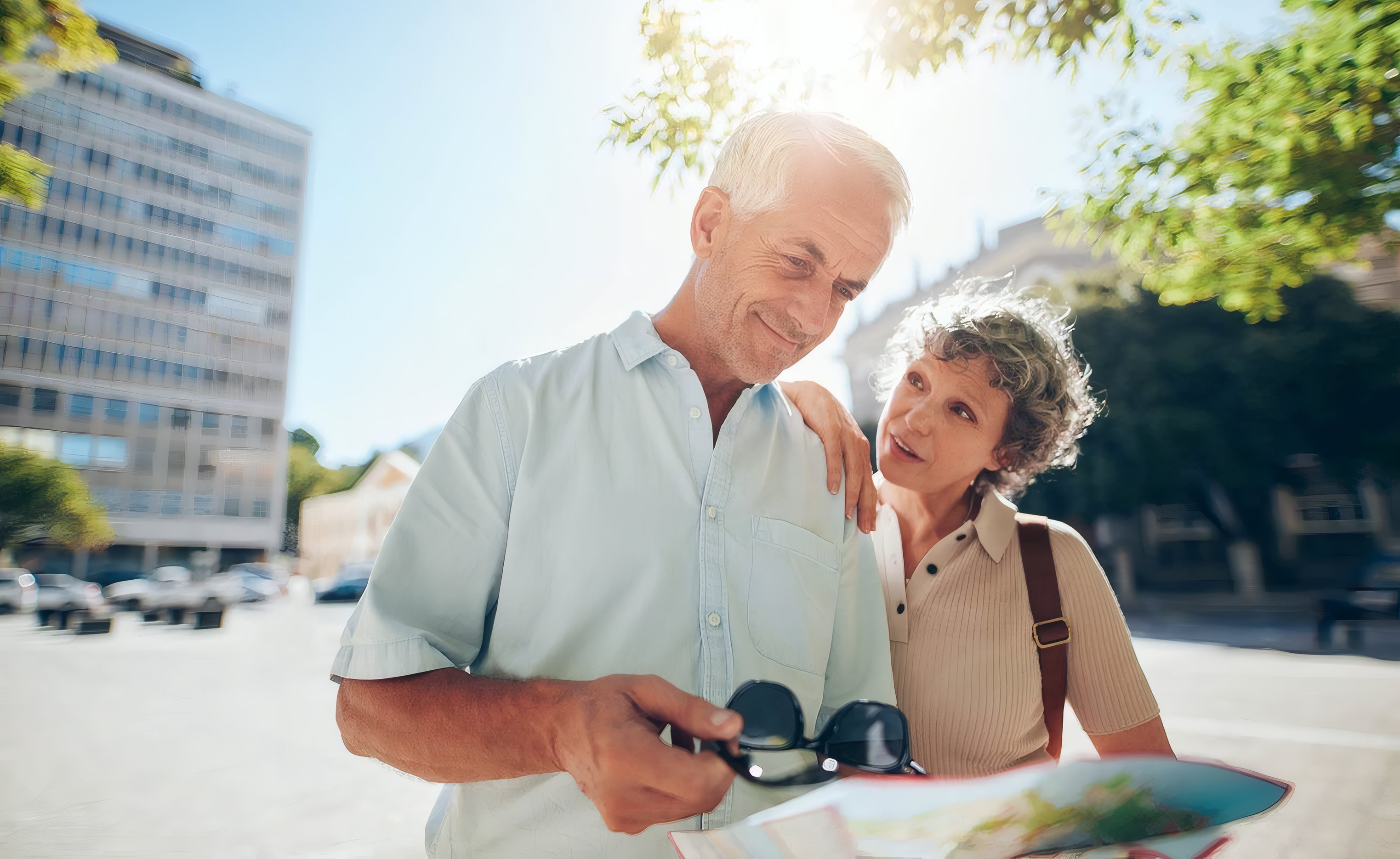 An older couple reading a map together with his glasses in hand