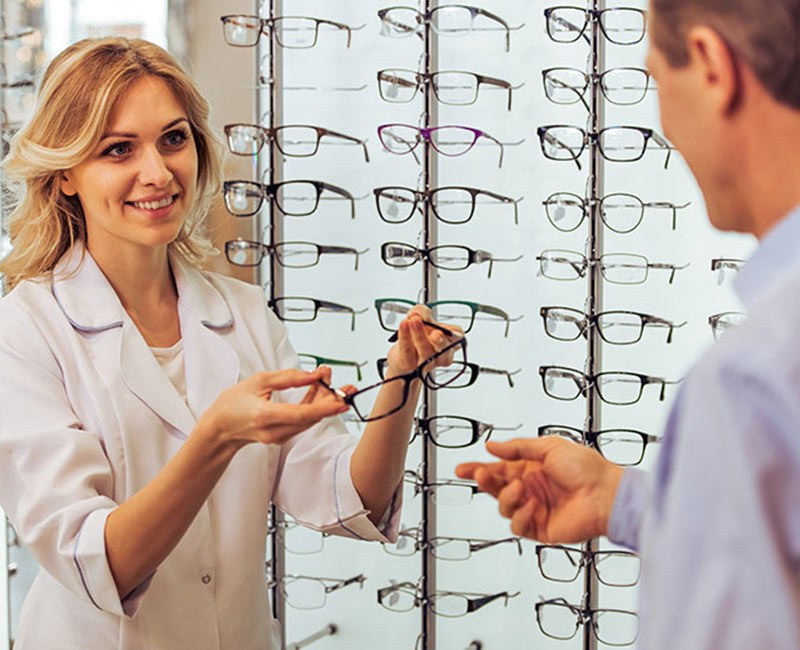 An optician helping a customer choose frames