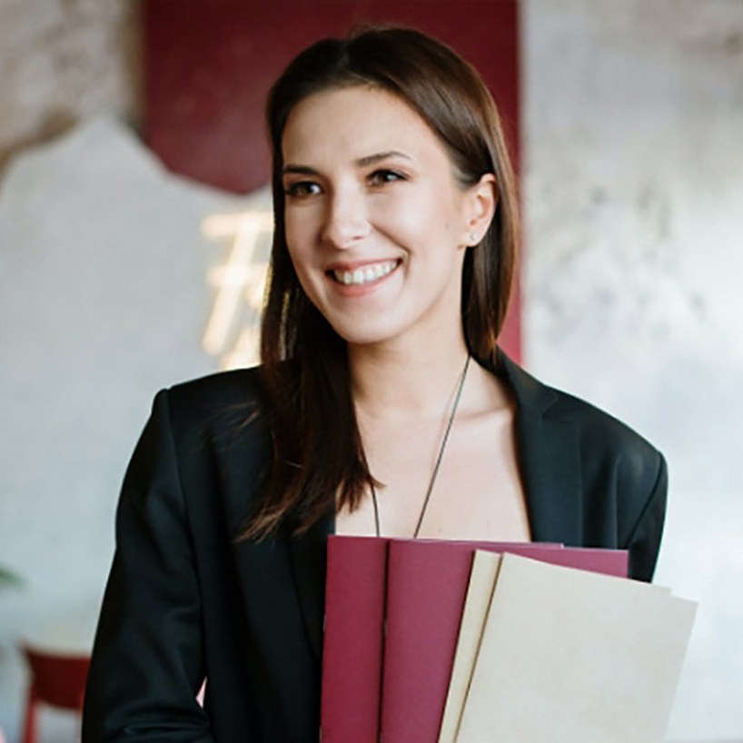 A host greeting guests with menus