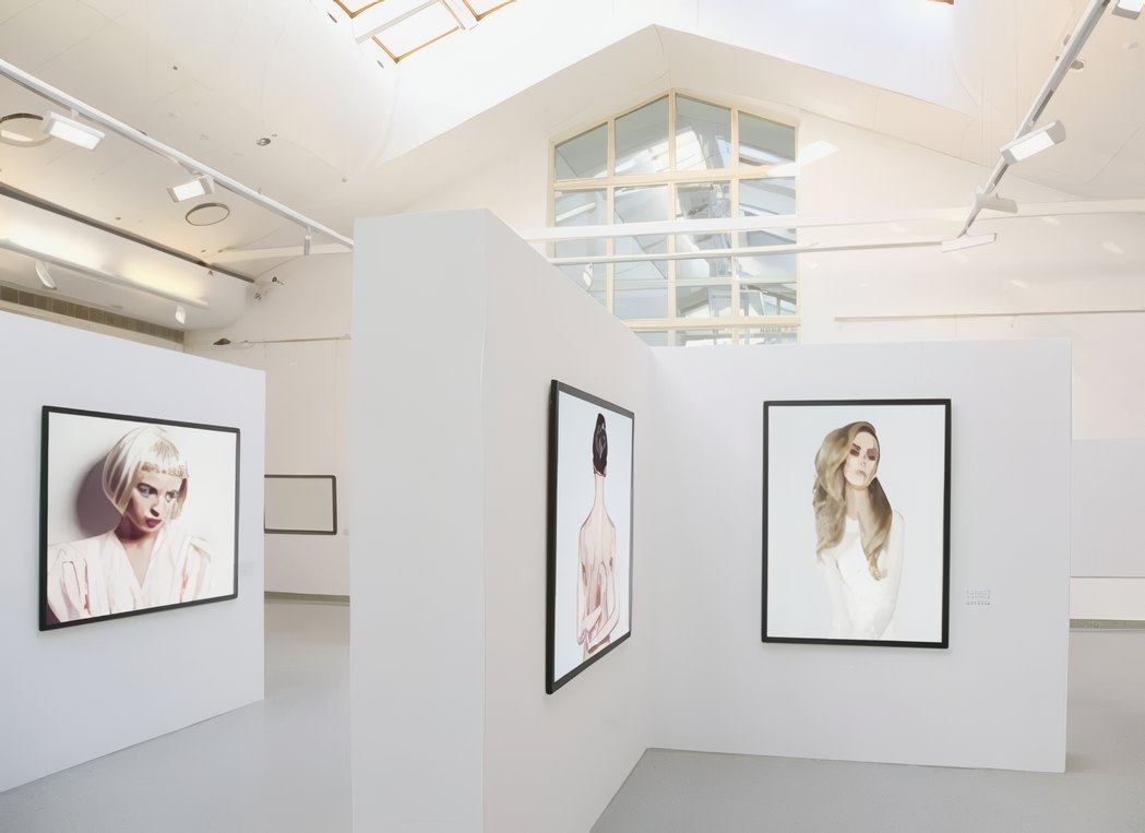 The gallery with framed portraits on white walls