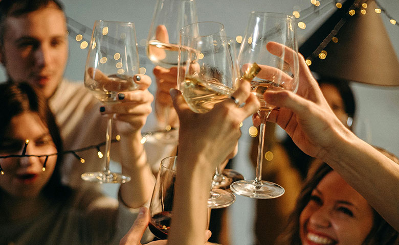 Friends toasting under string lights