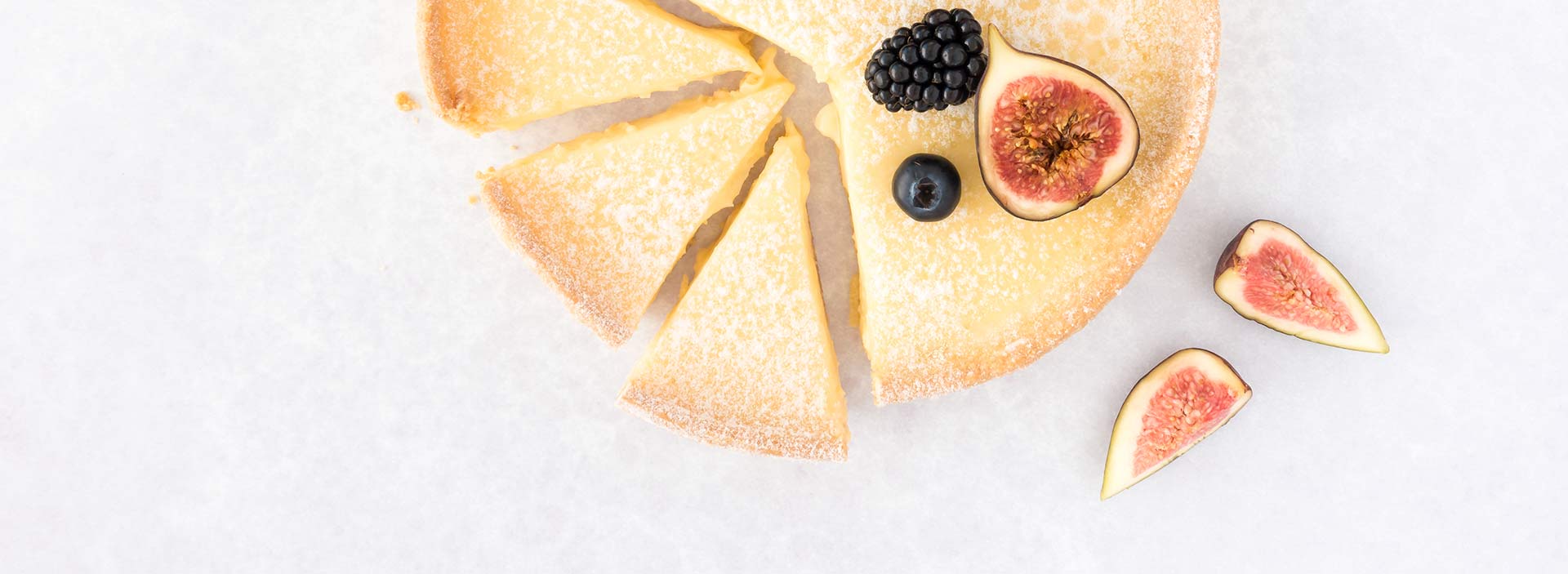 A fig tart cut in slices on white