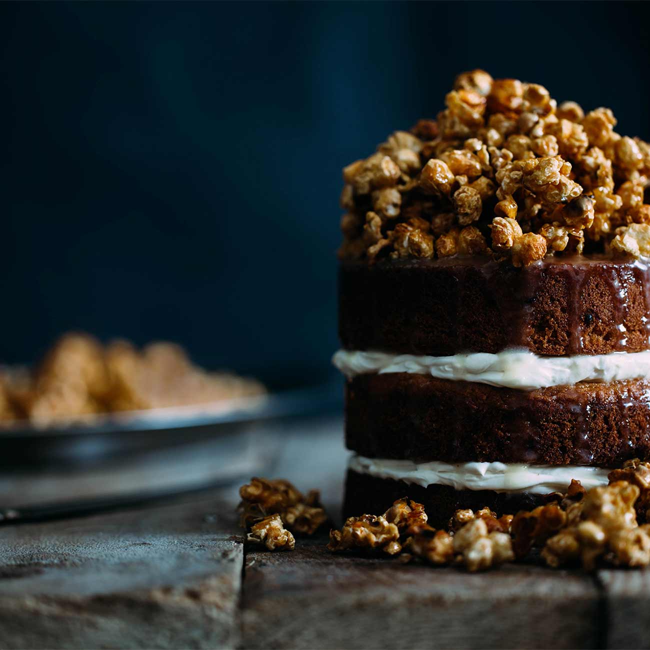 A layered chocolate cake topped with caramelised nuts
