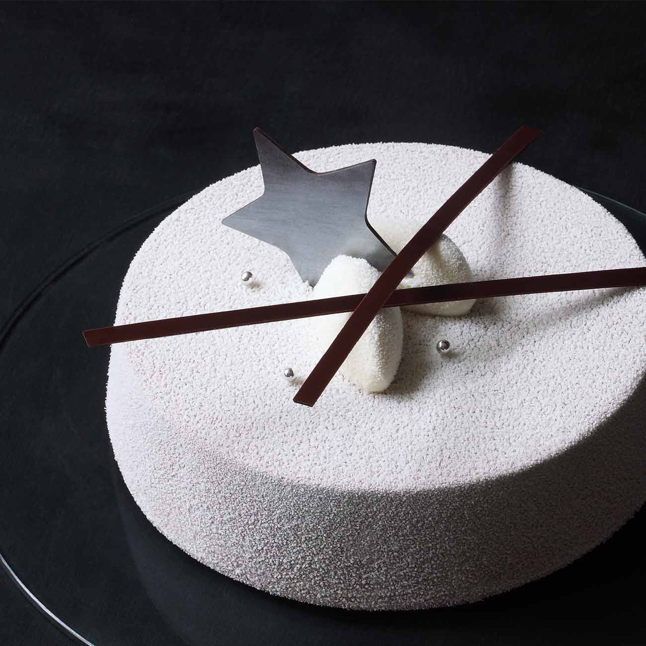 A white velvet entremet with a chocolate star