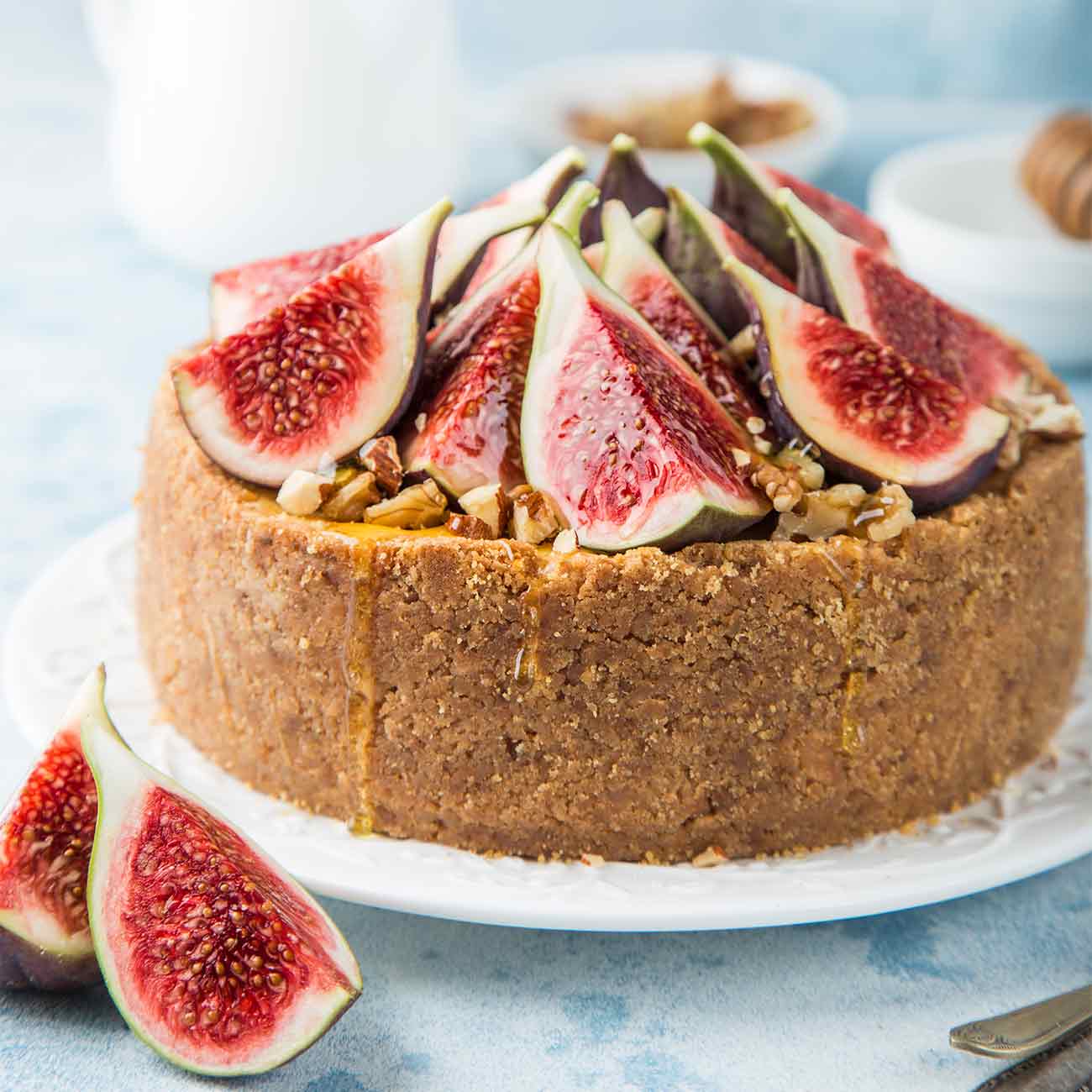 A whole fig and honey cake on a white plate