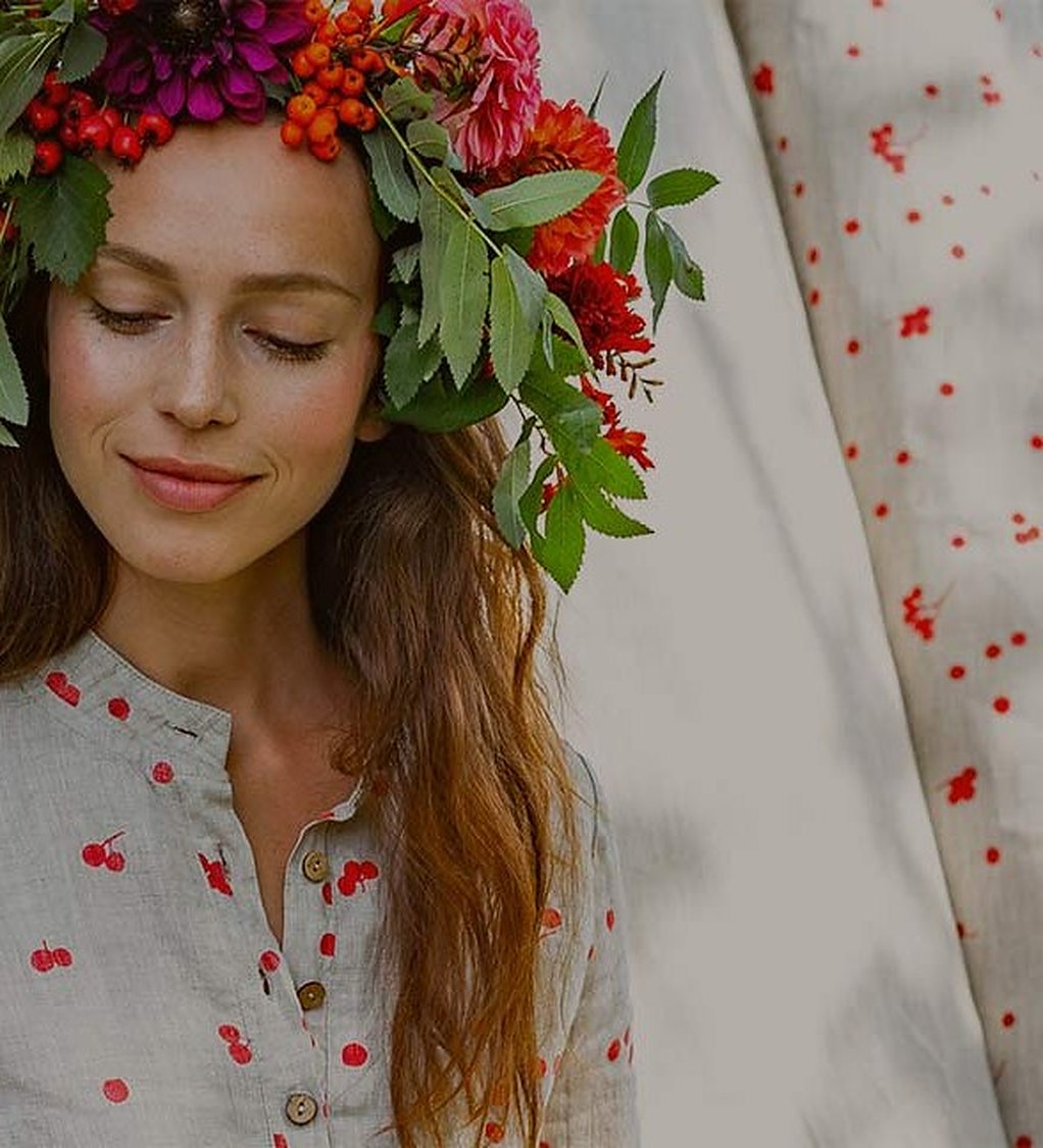 A woman in a flower crown and a cherry-print blouse