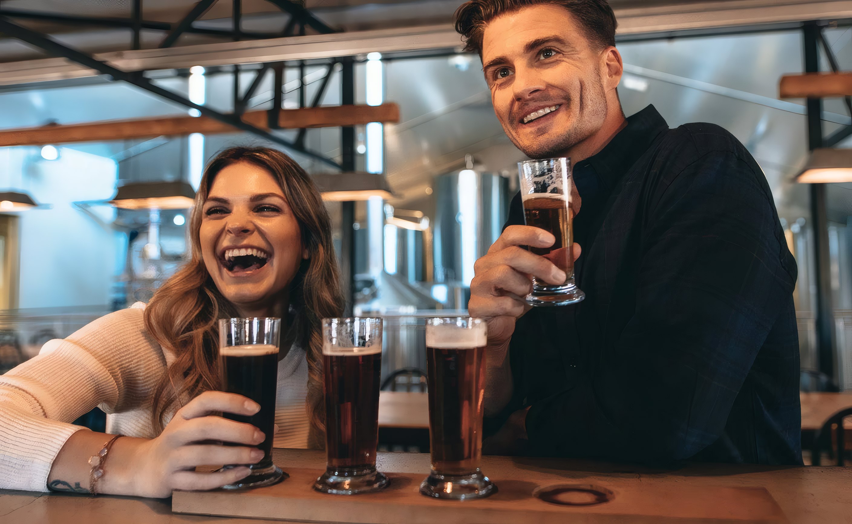 Friends raising pints at the bar