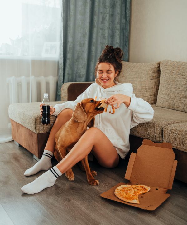 A friend with a dog and a pizza box on the floor