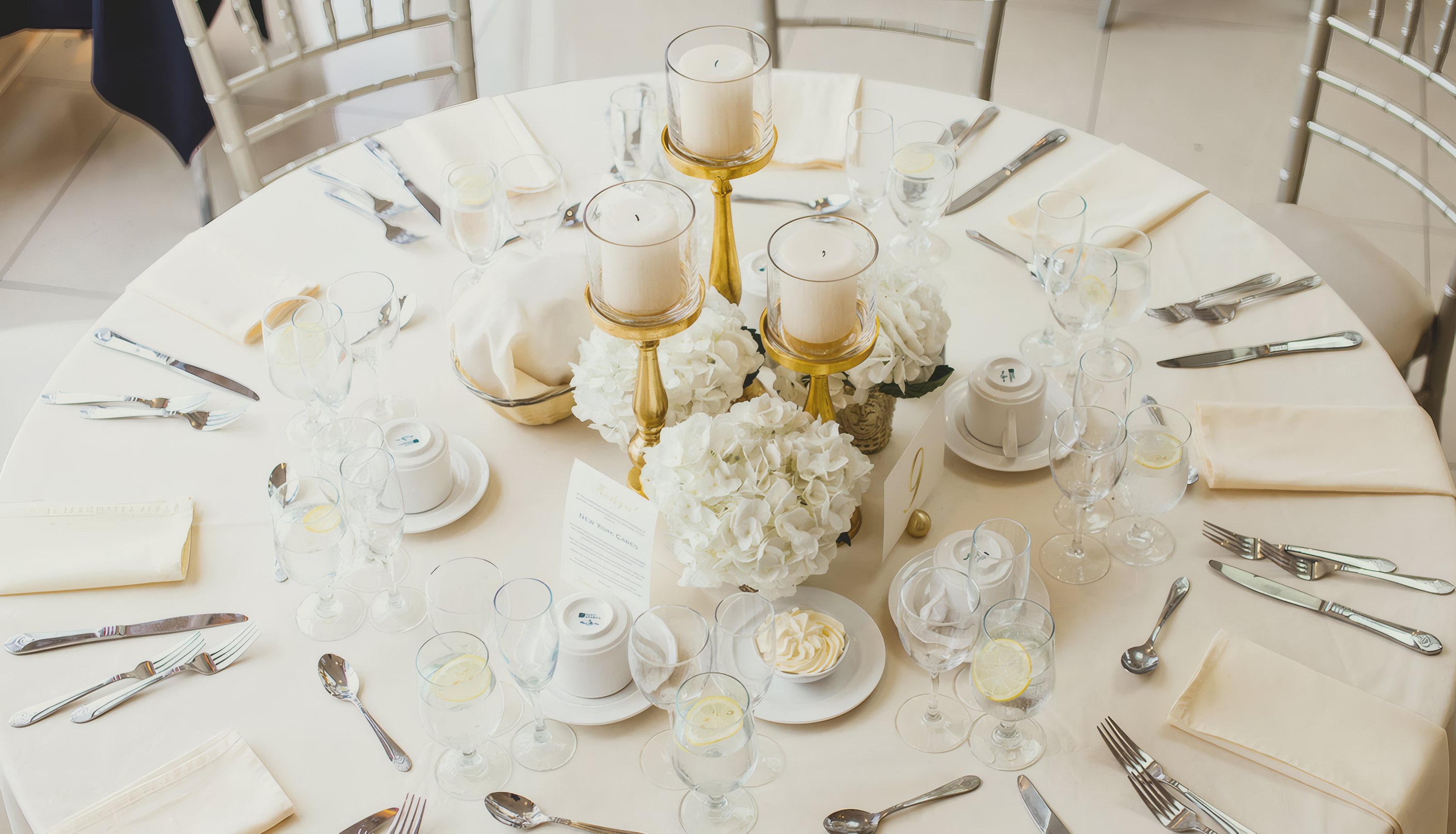 A round wedding table laid with candles and white flowers