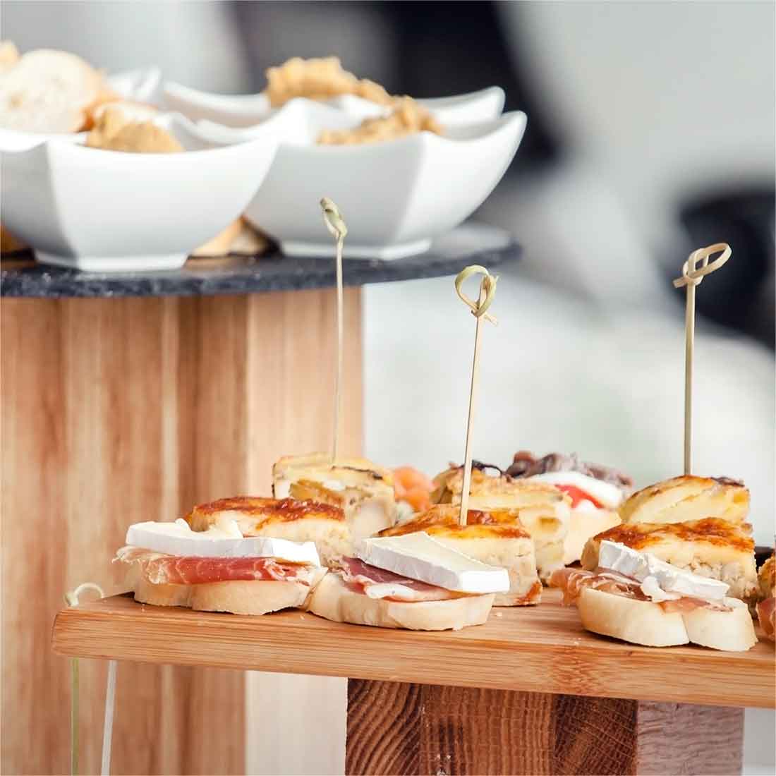 Small sandwiches set out on wooden stands