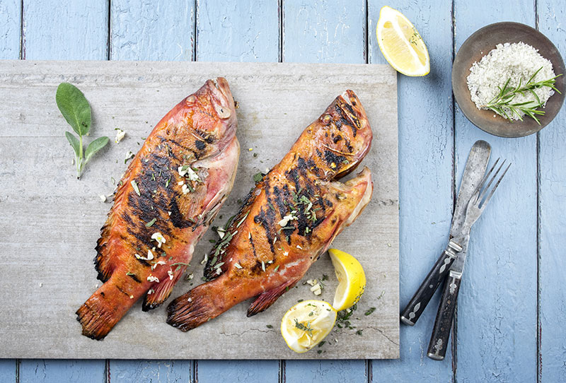 Two grilled fish with lemon and herbs
