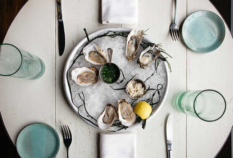 Oysters on ice on a table set for two