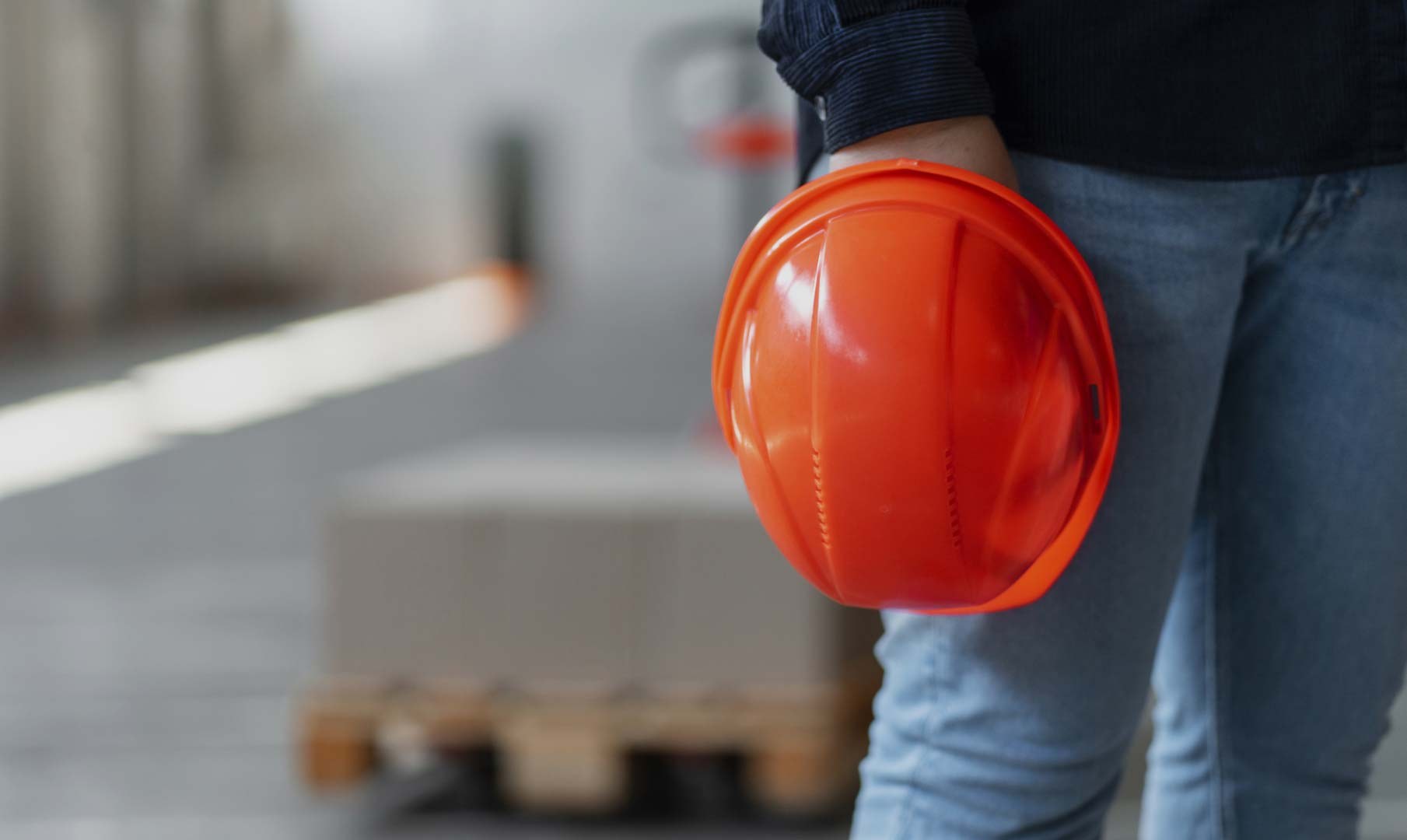 A crew member holding a hard hat in the depot
