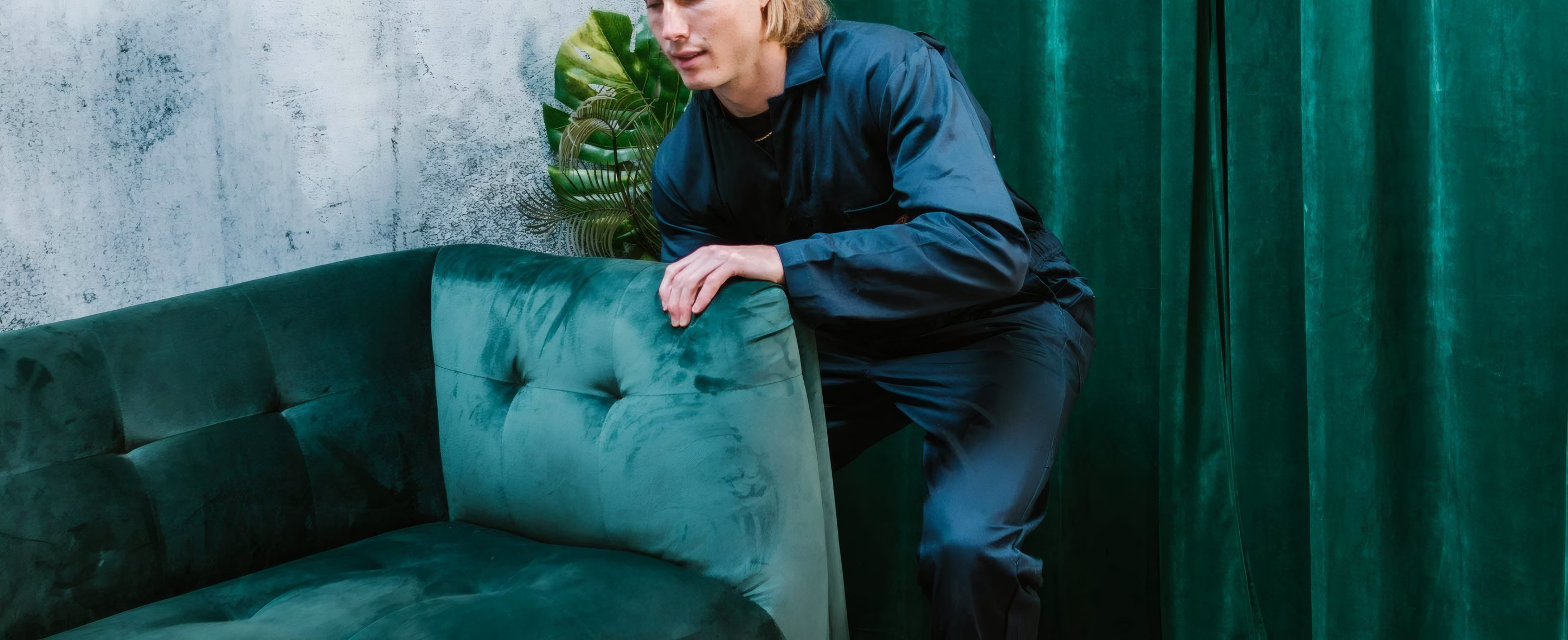 A mover setting down a green sofa