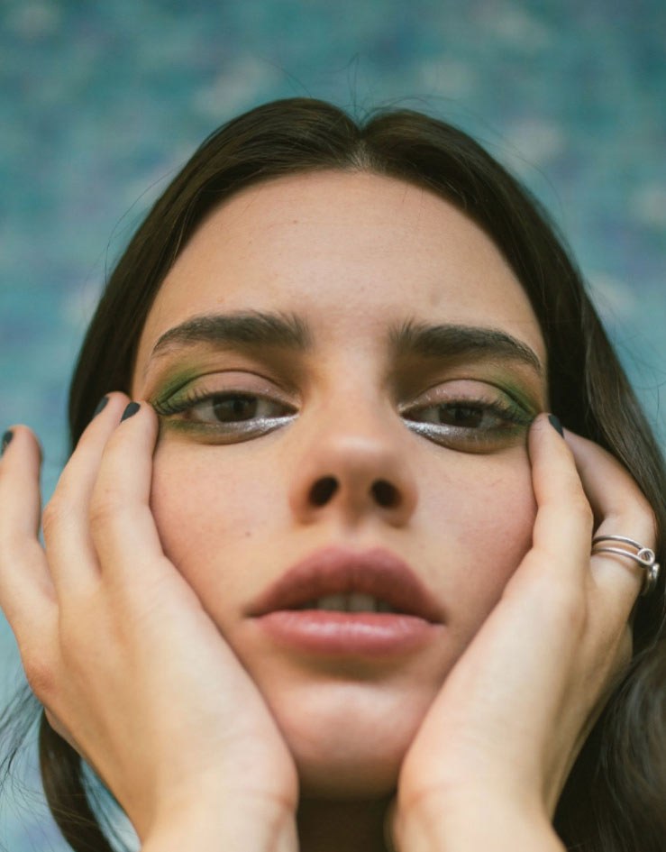 A close portrait of a woman with her face in her hands