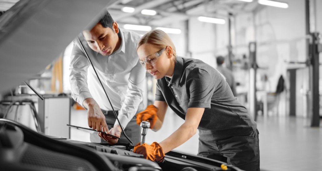 Two technicians at an open bonnet