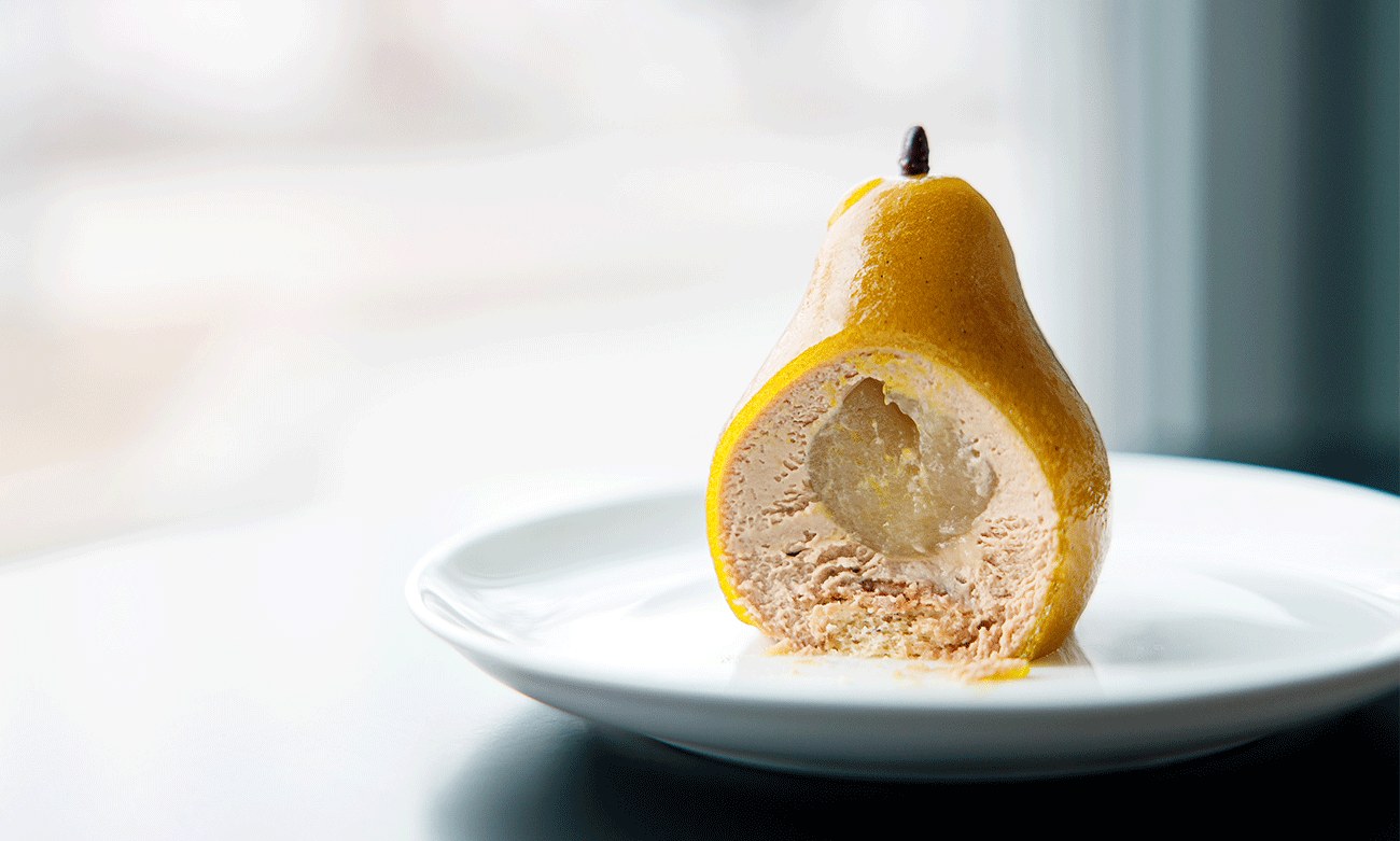 A poached pear on a white plate