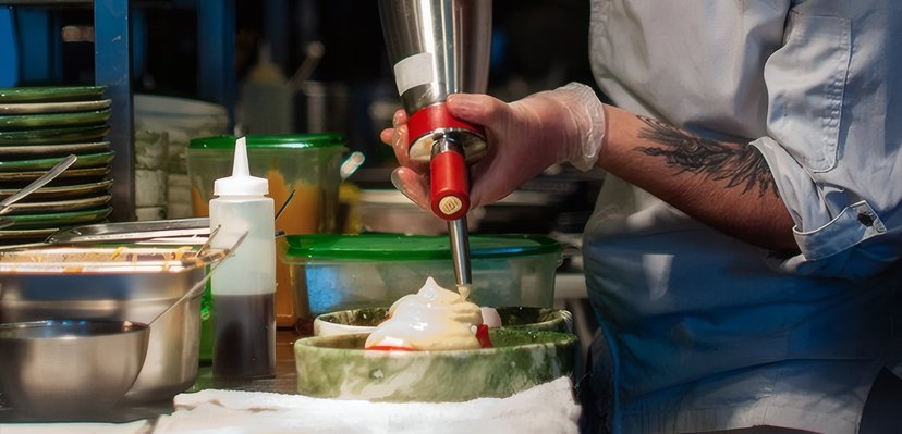 A chef piping a garnish