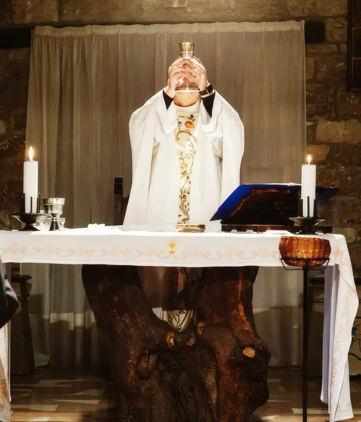 A priest at the altar between two candles