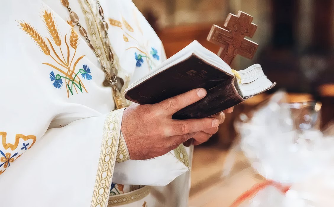 A girl praying with a rosary beside her father