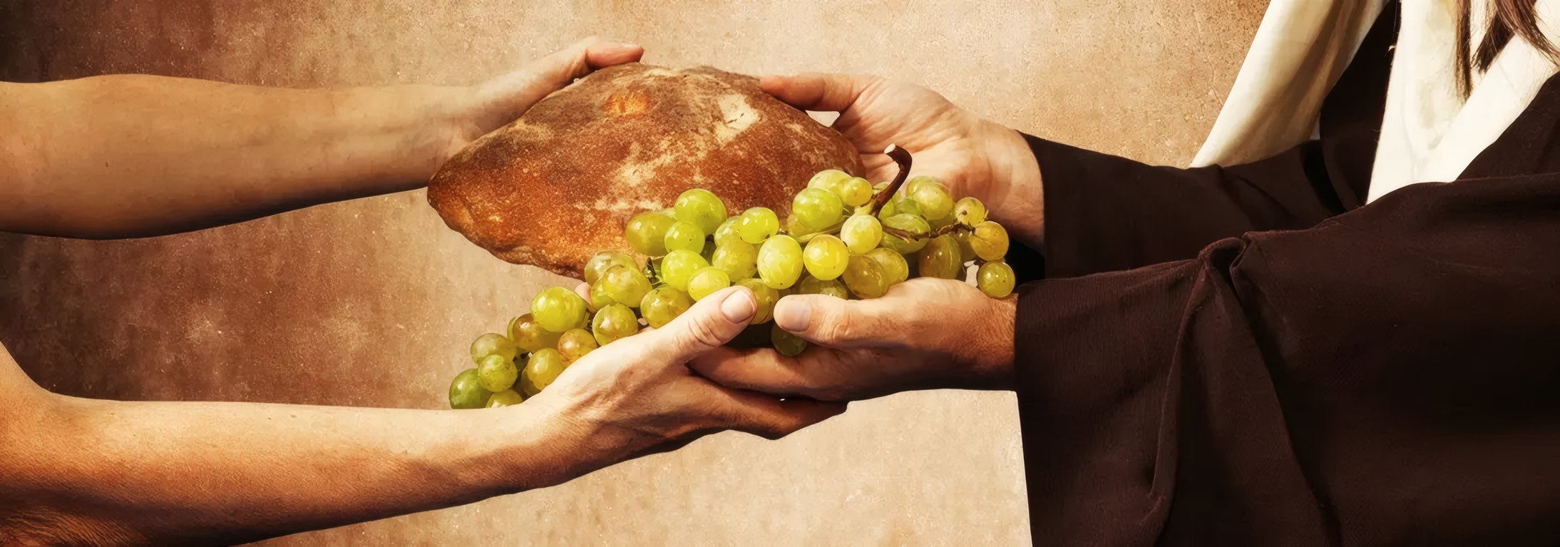 Hands sharing bread and grapes
