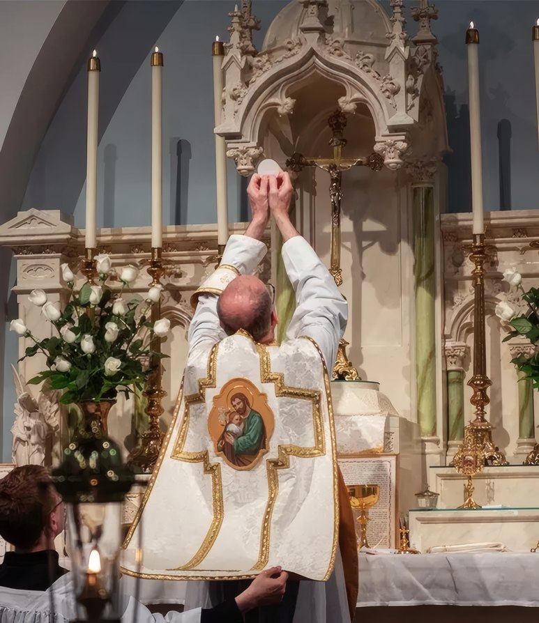 A priest raising the host before the altar