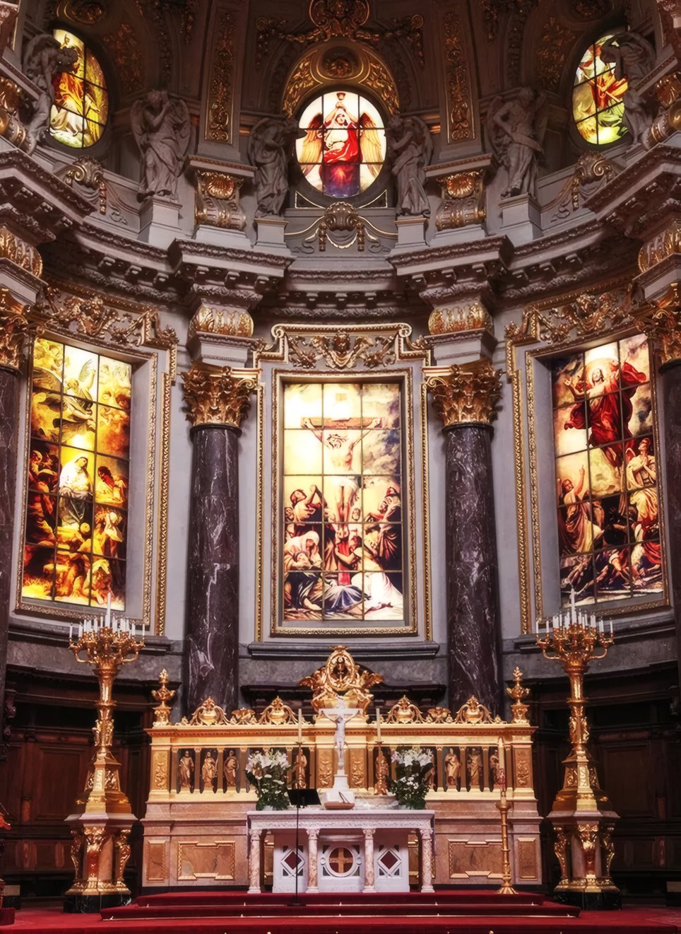 Stained glass windows above a gilded altar