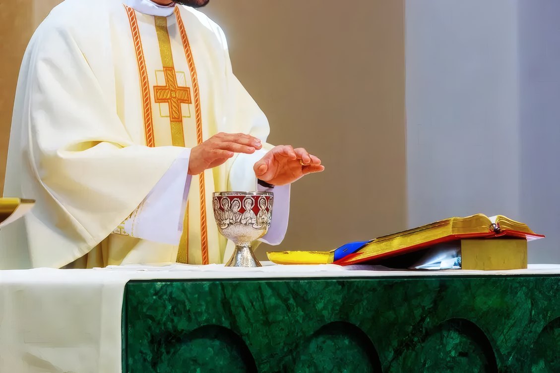 A priest blessing the chalice