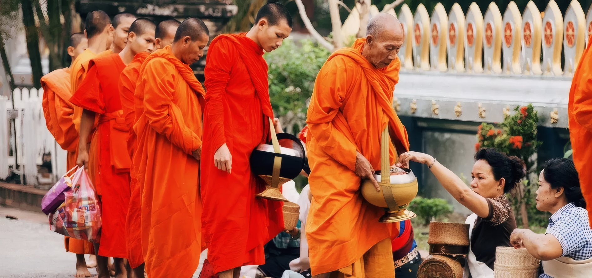 Villagers offering alms to a line of monks
