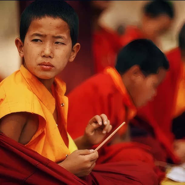 A young monk lighting incense