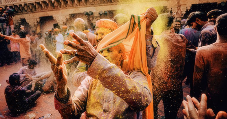 Devotees covered in coloured powder at Holi