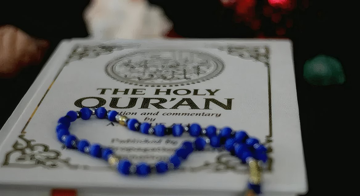 The Holy Quran with blue prayer beads