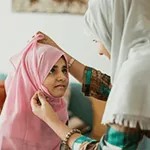 A mother adjusting her daughter's scarf