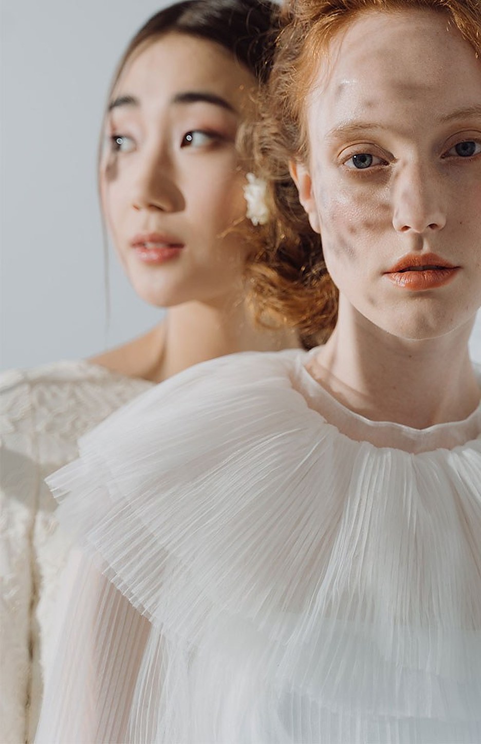 Two women in ivory ruffled collars