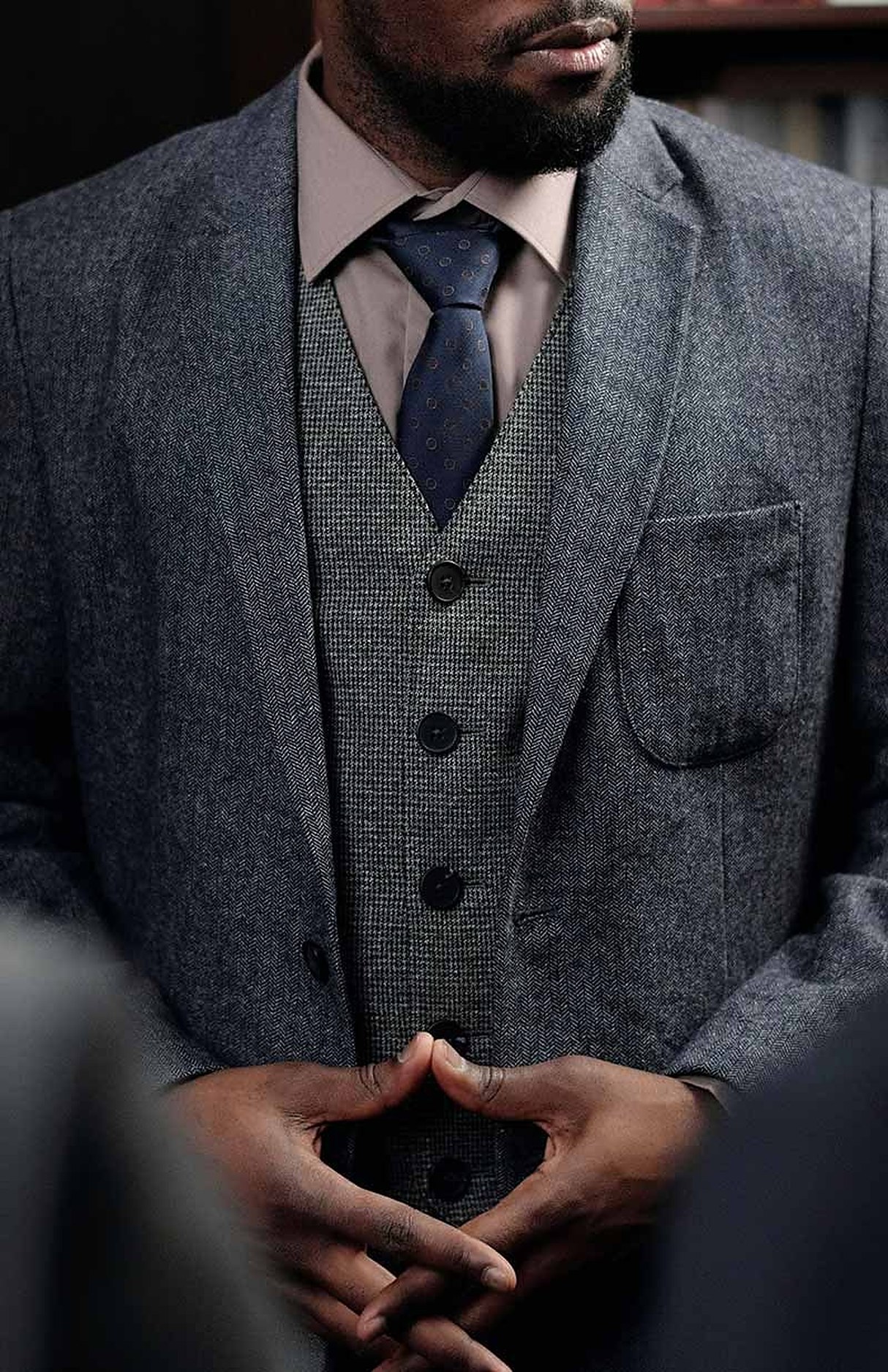 A man in a grey three-piece suit
