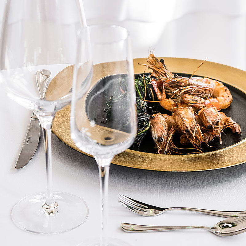 Grilled prawns on a gold-rimmed plate