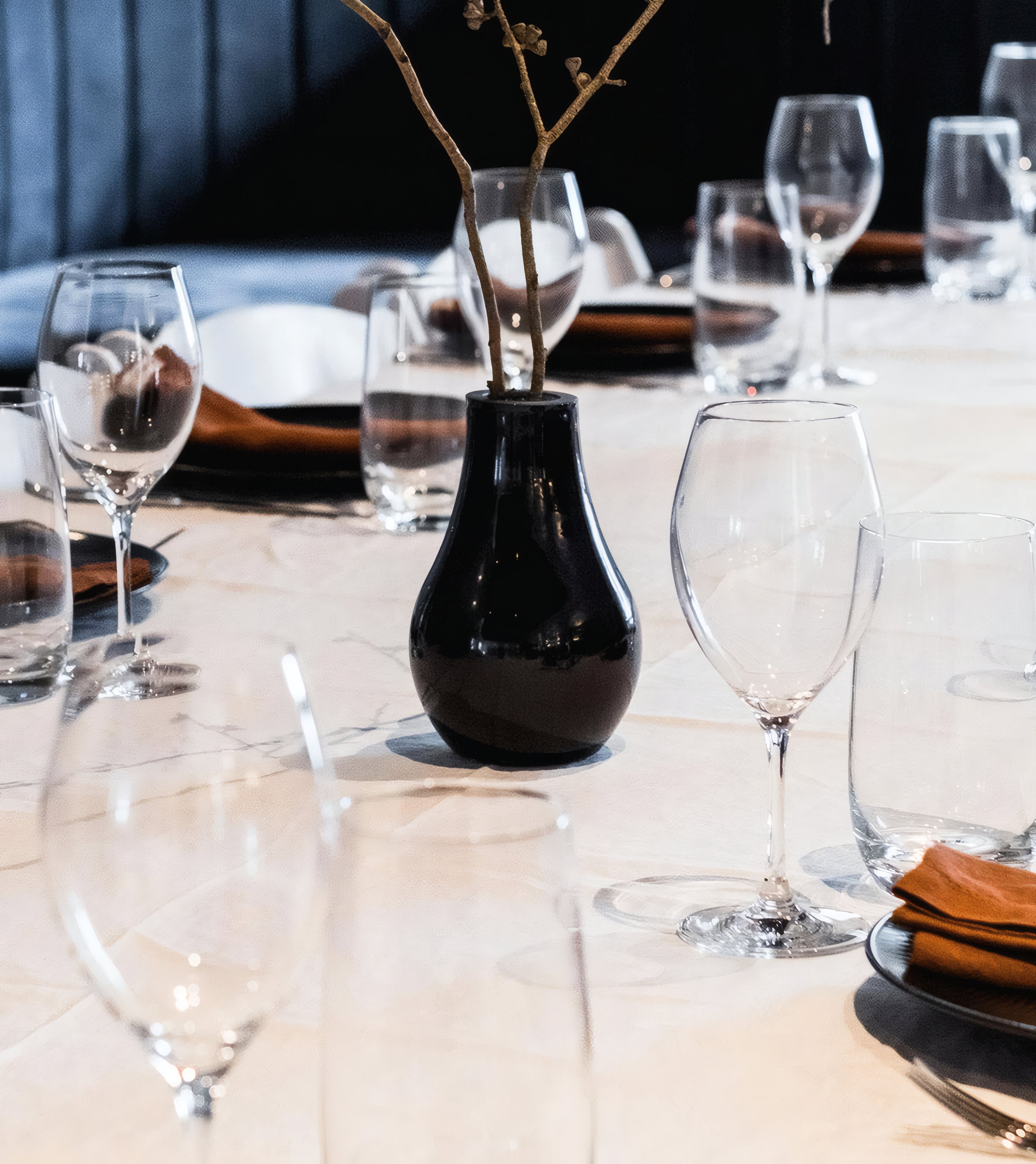 A black vase and glasses on a white table