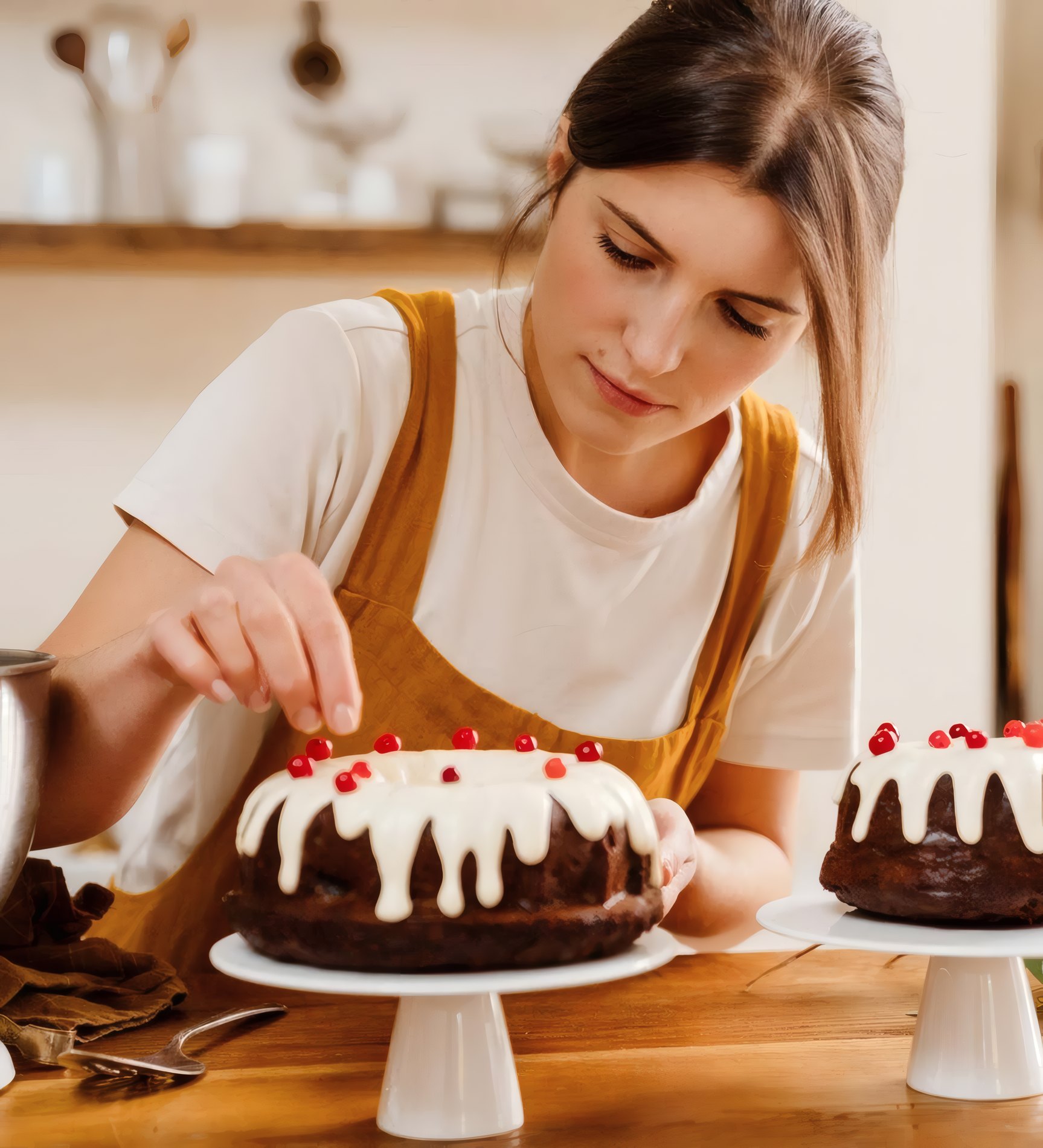 A pastry chef dressing a cake with cherries