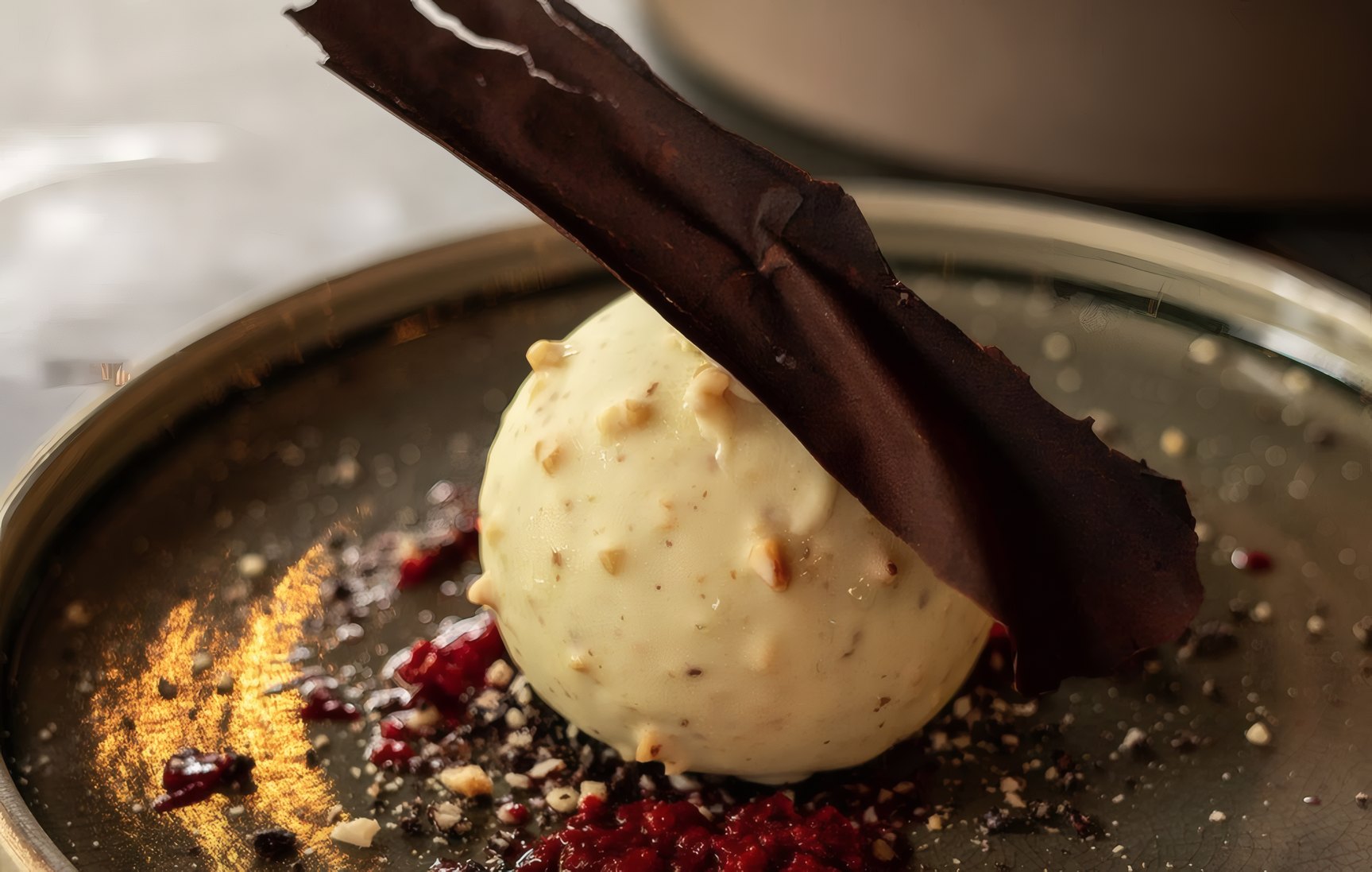 A white chocolate dome with a dark chocolate shard
