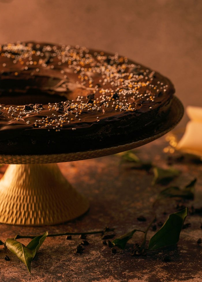 A chocolate cake on a gold stand