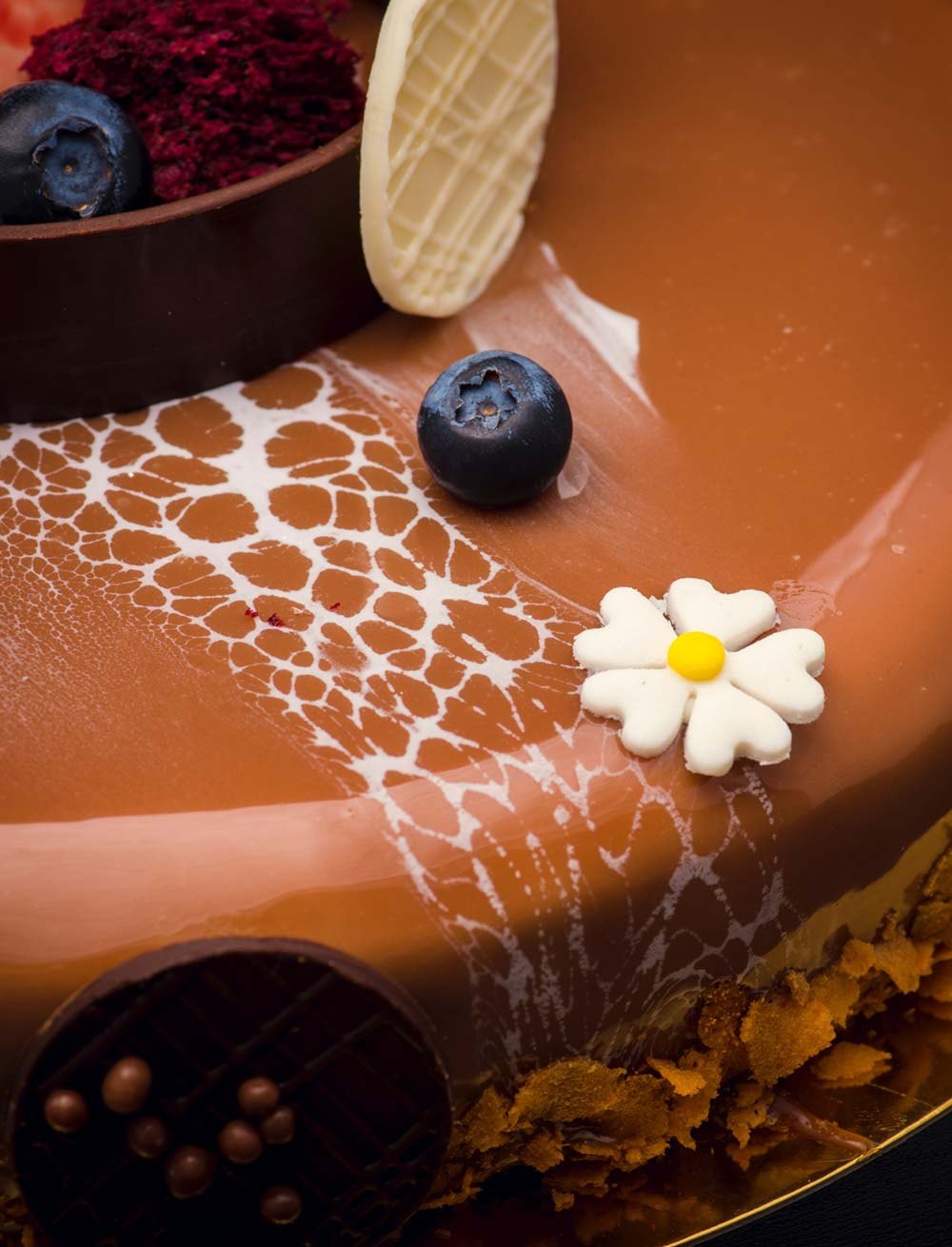 A caramel mirror cake with a daisy