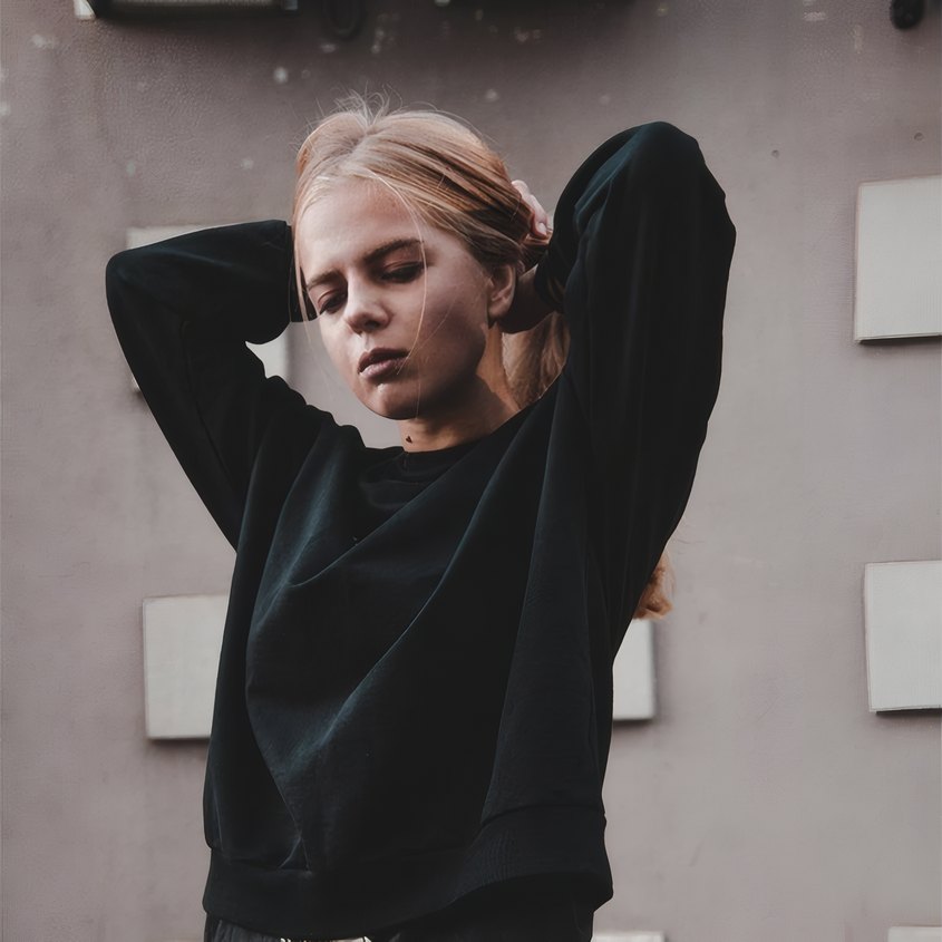 The store manager in a black jumper against the shop's grey wall