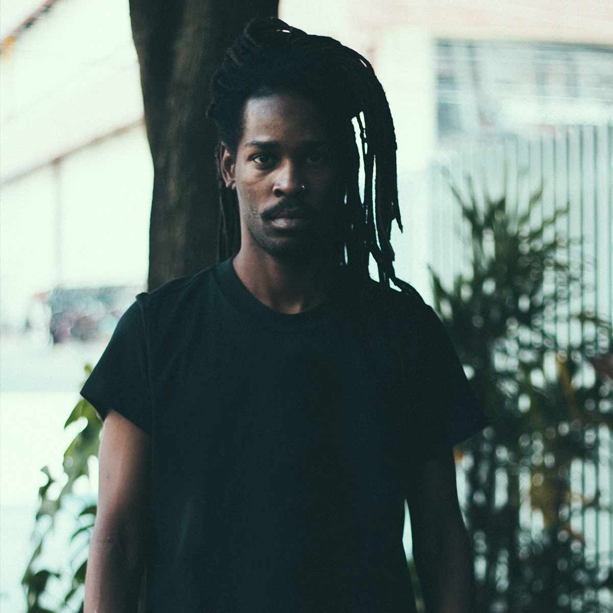 A man in a black tee under the trees