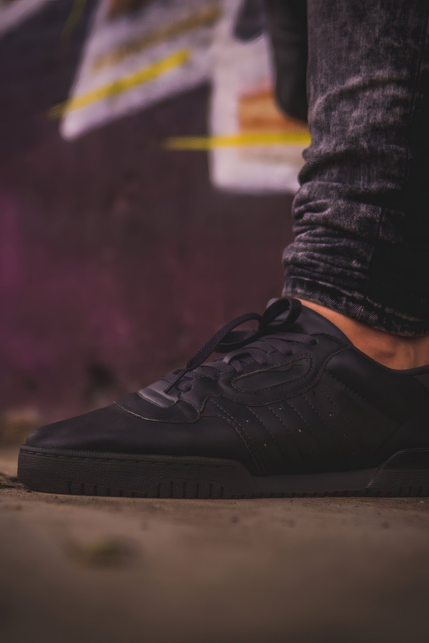 A black sneaker on a dark street
