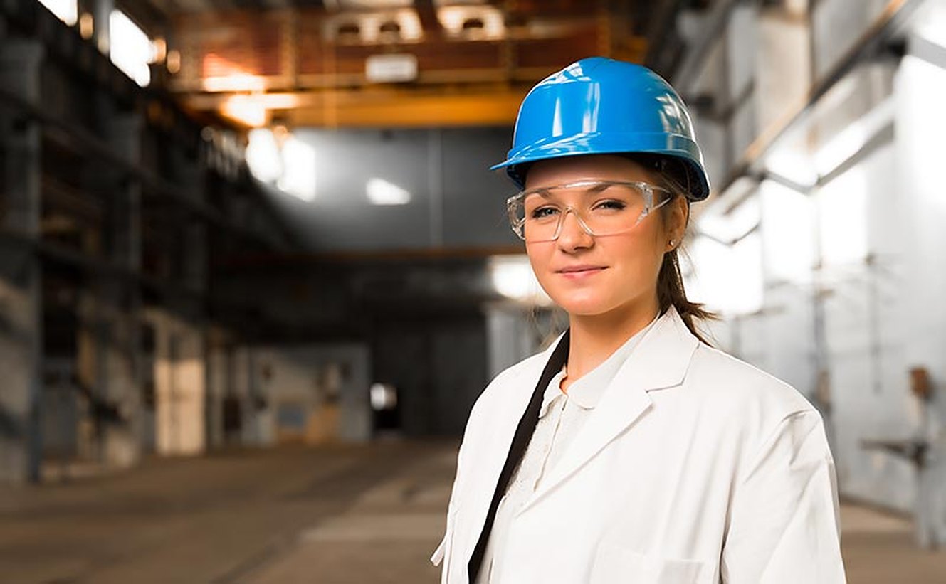 An inspector in a hard hat on a plant floor