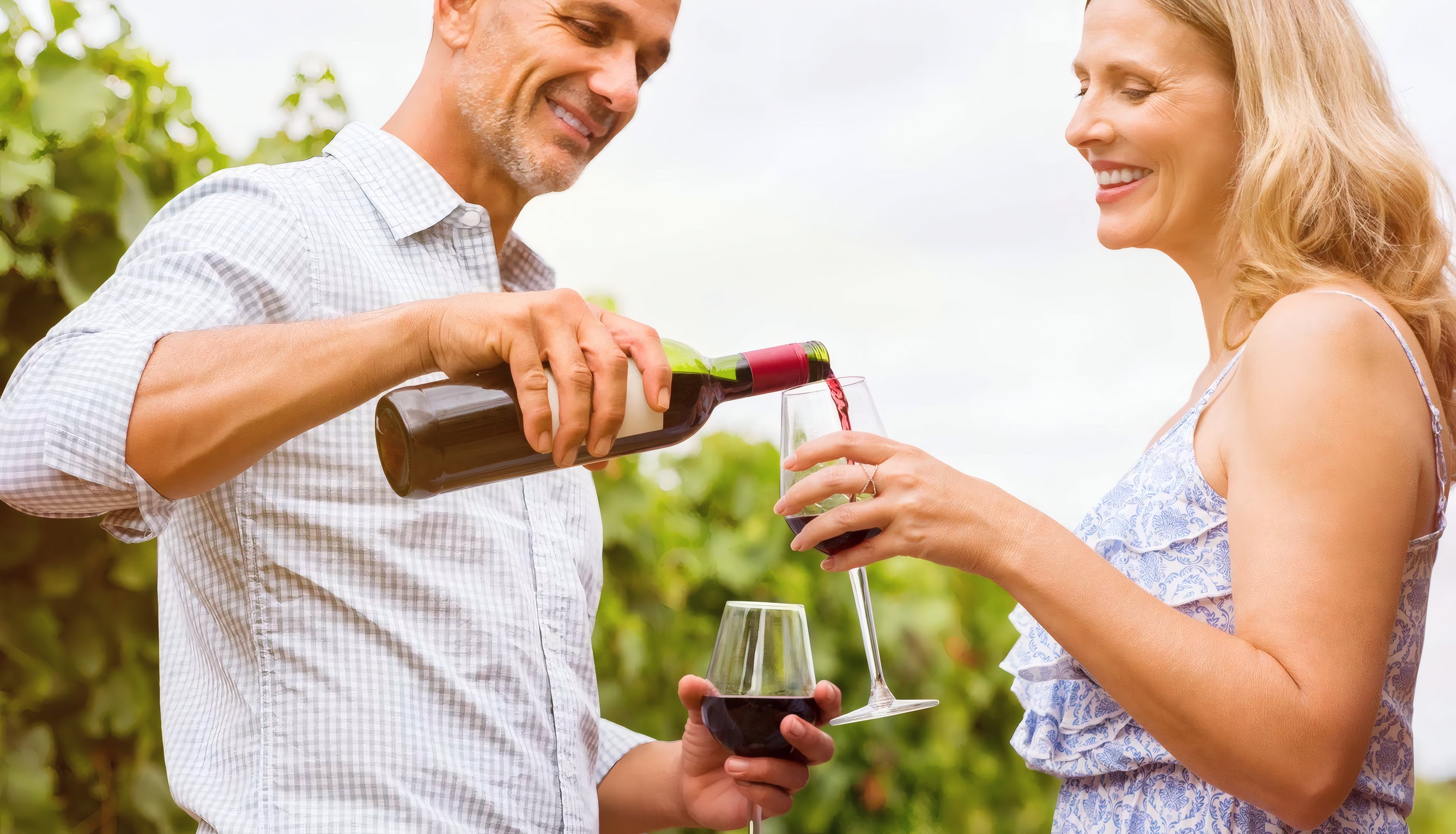 A couple pouring wine among the vines